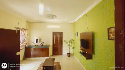 a living room with green walls and a tv at AAK Hills stay villa in Kodaikānāl