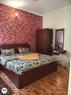a bedroom with a bed and a red wall at AAK Hills stay villa in Kodaikānāl