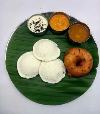 a green plate with food on a banana leaf at Puthooram Veedu in Chakkarakkal