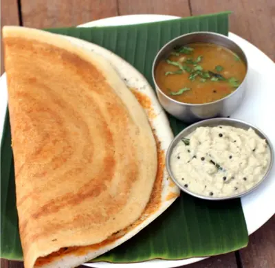 a plate of food with chapati and a bowl of dip at Puthooram Veedu in Chakkarakkal