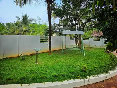 a playground in a yard with a fence at Tranquil Nest Villa - 4BHK Villa - Entire Villa stay in Wayanad in Kalpetta