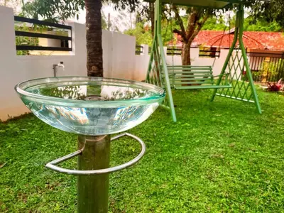 a glass bowl on a stand in a yard at Tranquil Nest Villa - 4BHK Villa - Entire Villa stay in Wayanad in Kalpetta