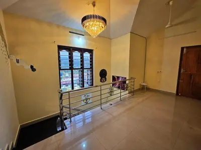an empty room with a window and a chandelier at Tranquil Nest Villa - 4BHK Villa - Entire Villa stay in Wayanad in Kalpetta