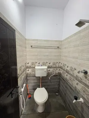 a bathroom with a toilet and a shower at Anchery homes in Trichūr
