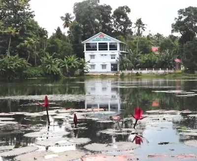 a house in the middle of a lake with lilies at Kerala Ayurveda and yoga for women sn in Ernakulam