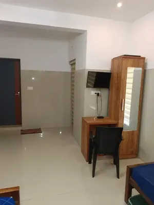 a living room with a desk and a chair at Kerala Ayurveda and yoga for women sn in Ernakulam