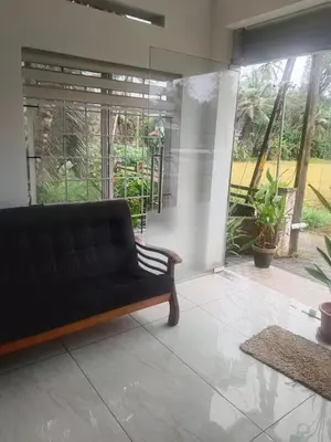 a living room with a couch and a large window at Kerala Ayurveda and yoga for women sn in Ernakulam