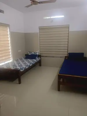 a bedroom with two beds and two windows at Kerala Ayurveda and yoga for women sn in Ernakulam