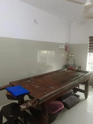 a large wooden table in a room at Kerala Ayurveda and yoga for women sn in Ernakulam