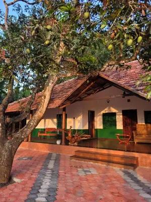 a house with a tree in front of it at Pariyarathu veedu, 4 Bed Hostel in Wayanad