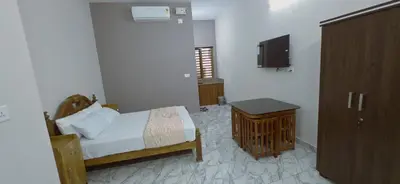 a bedroom with a bed and a tv on a wall at Alanchery Residency in Cheruthuruthi