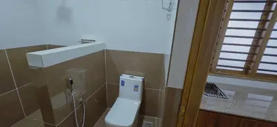 a bathroom with a toilet in the corner of a room at Alanchery Residency in Cheruthuruthi