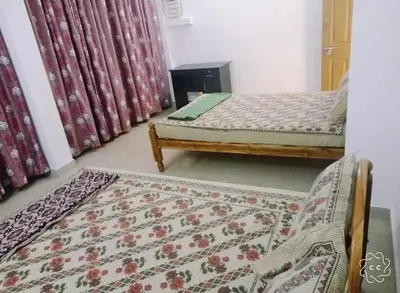 a room with two beds and a rug at Alanchery Residency in Cheruthuruthi