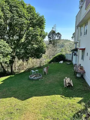 a yard with benches and a fire pit next to a building at The Wild House in Kotagiri