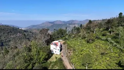 a train is parked on the side of a hill at The Wild House in Kotagiri