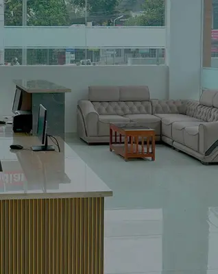 a living room with couches and a table and a tv at Hotel Queen Maria in Kizhillam