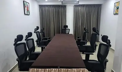 a conference room with a long table and chairs at Hotel Queen Maria in Kizhillam