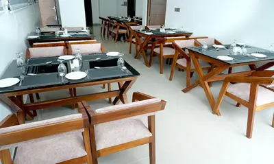a group of tables and chairs in a room at Hotel Queen Maria in Kizhillam