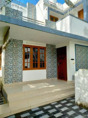 a house with a red door and a tile floor at Peaceful Vacation Home Near the City in Cochin