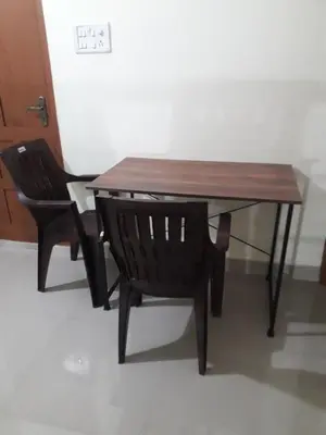 a wooden table and a chair sitting next to a table at Peaceful Vacation Home Near the City in Cochin