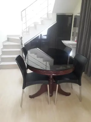 a black piano with a glass table next to a staircase at Peaceful Vacation Home Near the City in Cochin