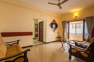 a living room with a couch and a ceiling fan at MK Residency in Coimbatore