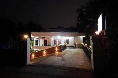 a house lit up at night with lights at Sreedevi Gardens in Irikkūr