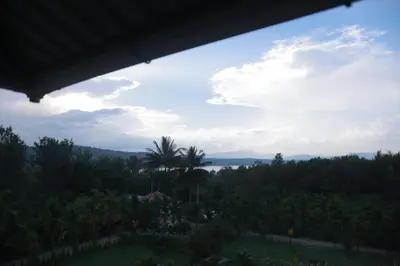 a view from the house of the ocean and palm trees at Coorg Riverness Resort in Kushālnagar