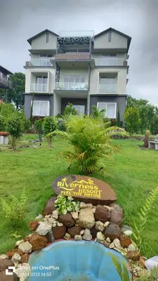 a building with a sign in front of a garden at Coorg Riverness Resort in Kushālnagar