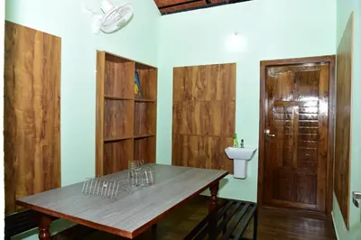 a room with a table and a toilet and a door at Samuals Villa Wayanad in Mānantoddy