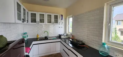 a kitchen with white cabinets and a sink at The Ark Haven Ooty by Scenic Serenity Stays in Ketti