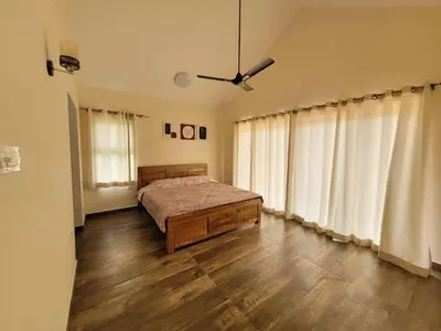 a bedroom with a bed and a ceiling fan at The Ark Haven Ooty by Scenic Serenity Stays in Ketti