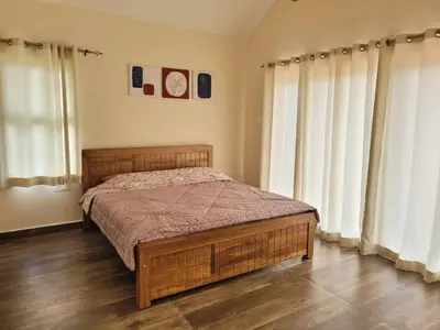 a bedroom with a bed and two large windows at The Ark Haven Ooty by Scenic Serenity Stays in Ketti