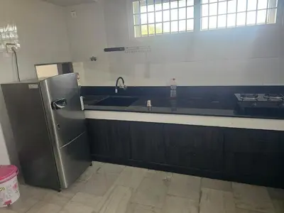 a kitchen with a sink and a refrigerator at Shiva Shambo Home Stay - Entire Villa in Coimbatore
