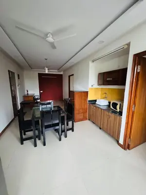 a kitchen and dining room with a table and chairs at Fully furnished 2BHK apartment near Gokulam in Mysore