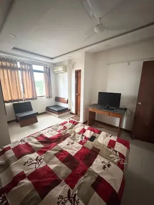a bedroom with a bed and a laptop on a desk at Fully furnished 2BHK apartment near Gokulam in Mysore
