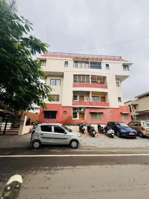 a car parked in front of a building with motorcycles at Fully furnished 2BHK apartment near Gokulam in Mysore