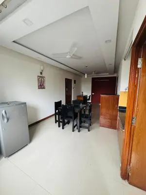 a dining room with a table and chairs in a room at Fully furnished 2BHK apartment near Gokulam in Mysore