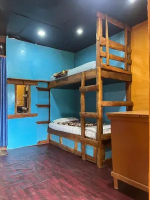 a bedroom with bunk beds in a room with blue walls at Kovilakam in Vattavada