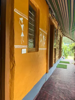 a yellow building with drawings on the side of it at Kovilakam in Vattavada