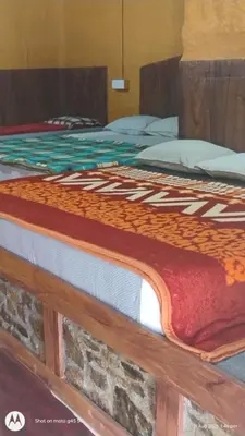 a bed with a blanket on top of it at Kovilakam in Vattavada