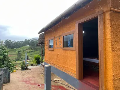 a small house with a large door on the side of it at Kovilakam in Vattavada