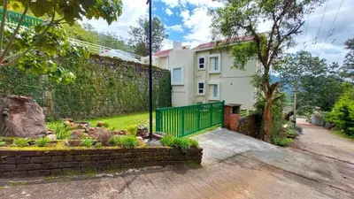 a house with a fence and a garden at Mayfield Valley Homestay in Kotagiri