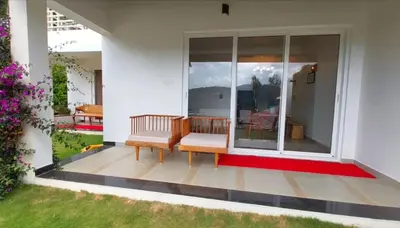 a patio with two benches on a house at Mayfield Valley Homestay in Kotagiri