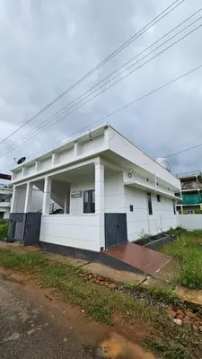 a white building on the side of a street at NAMERA Serviced Apartments in Gonikoppal