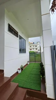 a balcony with a green rug on the floor at NAMERA Serviced Apartments in Gonikoppal