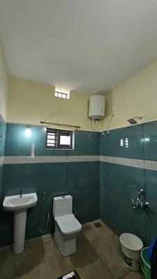 a bathroom with a toilet and a sink at NAMERA Serviced Apartments in Gonikoppal