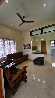 a living room with a couch and a ceiling fan at NAMERA Serviced Apartments in Gonikoppal