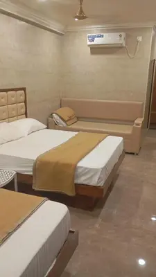 a room with two beds and a air conditioner at Hotel Maharajas in Kāmānayakkanpālaiyam