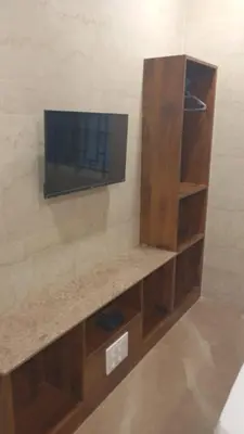 a tv sitting on a shelf in a room at Hotel Maharajas in Kāmānayakkanpālaiyam
